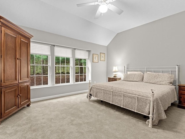 bedroom with light carpet, baseboards, lofted ceiling, and a ceiling fan