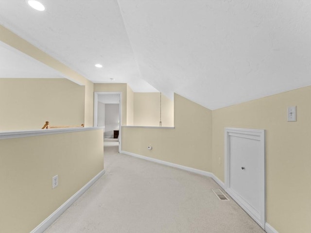 additional living space featuring lofted ceiling, baseboards, light carpet, and recessed lighting