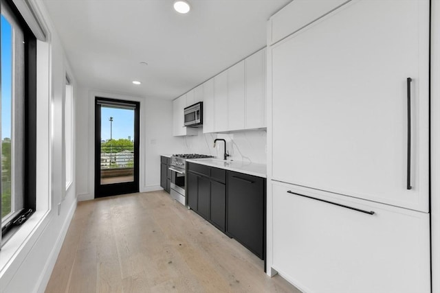 50 Leo M Birmingham Pkwy Unit 509, Boston, MA 02135 - kitchen featuring appliances with stainless steel finishes, white cabinets, light wood-type flooring, recessed lighting, and light countertops