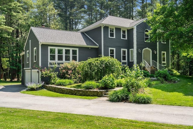 1199 N Rd, Carlisle, MA 01741 - view of front facade featuring roof with shingles, a chimney, driveway, an attached garage, and a front yard