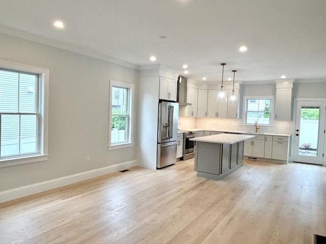 50 York Ave Unit 50, Watertown, MA 02472 - kitchen featuring stainless steel appliances, decorative backsplash, light countertops, a center island, and crown molding