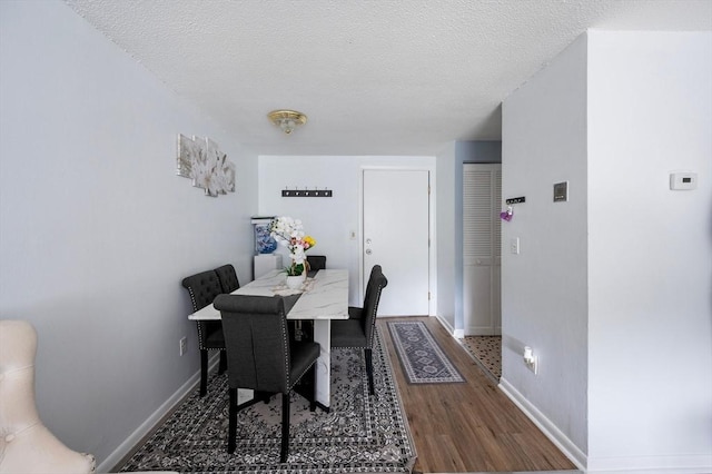 135 Grove St Unit 145, Rockland, MA 02370 - dining room featuring wood finished floors and a textured ceiling