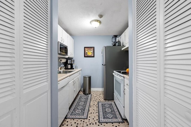 135 Grove St Unit 145, Rockland, MA 02370 - kitchen featuring white appliances, white cabinets, light countertops, and a textured ceiling