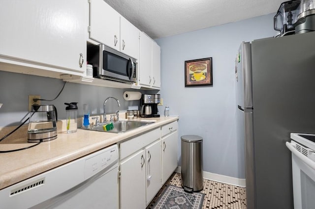 135 Grove St Unit 145, Rockland, MA 02370 - kitchen featuring appliances with stainless steel finishes, light countertops, white cabinetry, and a textured ceiling