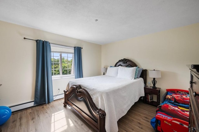 135 Grove St Unit 145, Rockland, MA 02370 - bedroom featuring wood finished floors, a baseboard radiator, and a textured ceiling