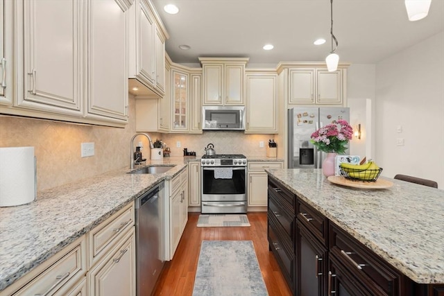 12 Bowood Ln Unit 36, Marlborough, MA 01752 - kitchen featuring stainless steel appliances, cream cabinets, a sink, dark wood-style floors, and light stone counters