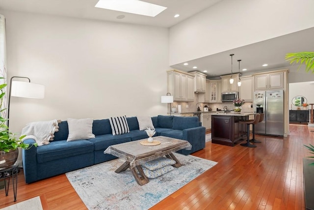 12 Bowood Ln Unit 36, Marlborough, MA 01752 - living room with a skylight, light wood finished floors, a towering ceiling, and recessed lighting