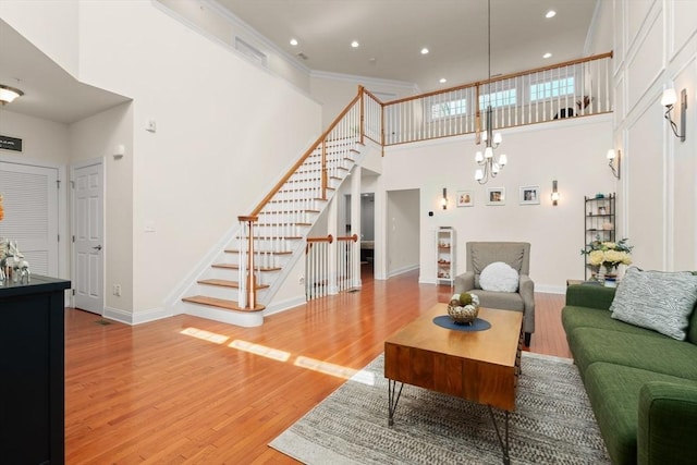 12 Bowood Ln Unit 36, Marlborough, MA 01752 - living room with a high ceiling, stairway, light wood-style floors, a chandelier, and baseboards