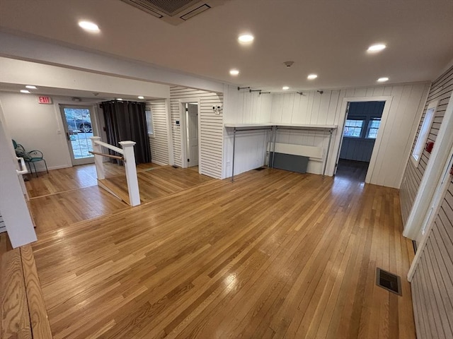 unfurnished living room featuring a wealth of natural light, light wood-type flooring, visible vents, and recessed lighting