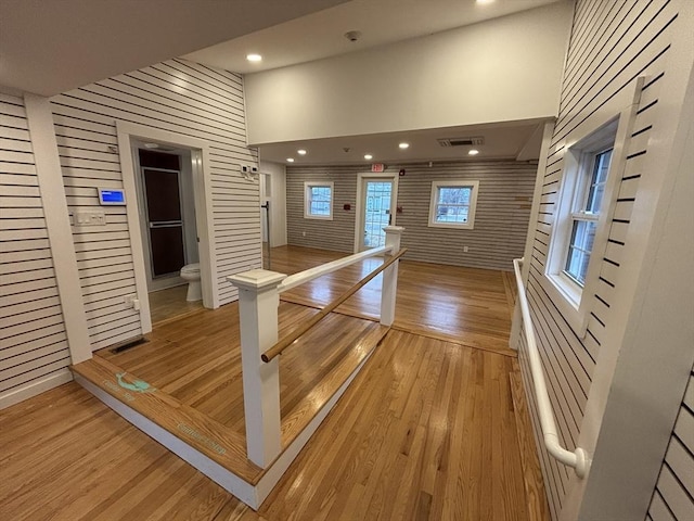 interior space with recessed lighting, a high ceiling, an upstairs landing, visible vents, and light wood-style floors