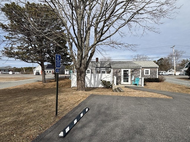 view of front facade with stone siding and fence