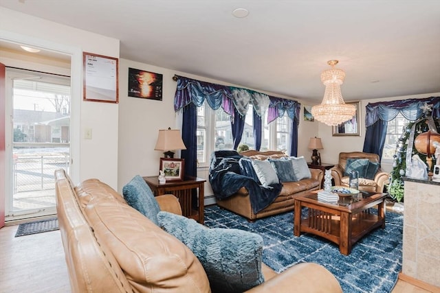 living room with a notable chandelier, dark wood-type flooring, and baseboard heating