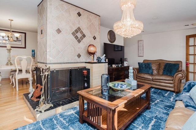 living room with hardwood / wood-style floors, a fireplace, and a chandelier