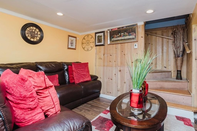 living room featuring hardwood / wood-style flooring, ornamental molding, and wood walls