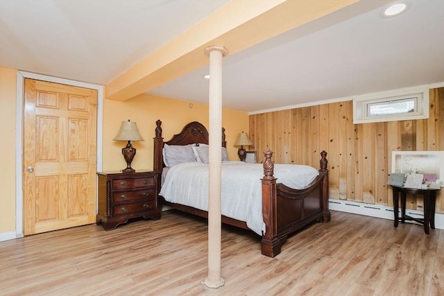 bedroom featuring hardwood / wood-style flooring, baseboard heating, and wood walls