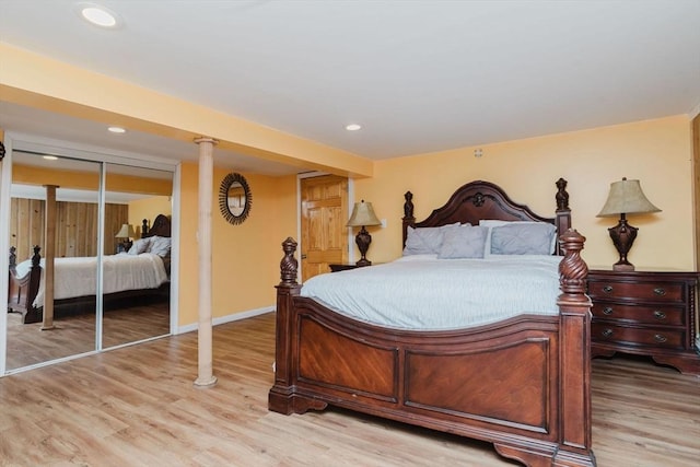 bedroom with light hardwood / wood-style floors and a closet