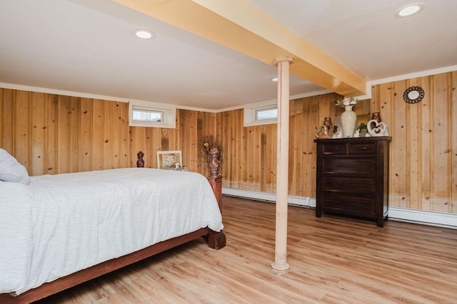 bedroom with hardwood / wood-style flooring, a baseboard radiator, ornamental molding, and wood walls