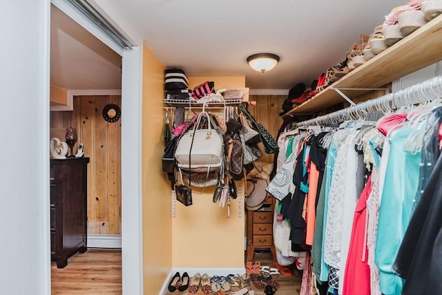 walk in closet with light hardwood / wood-style floors