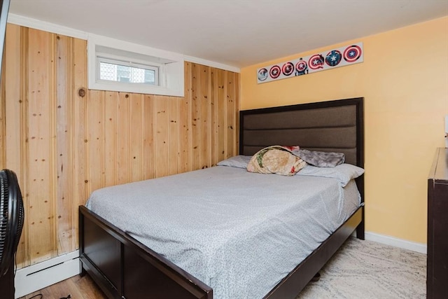 bedroom with baseboard heating and wood walls