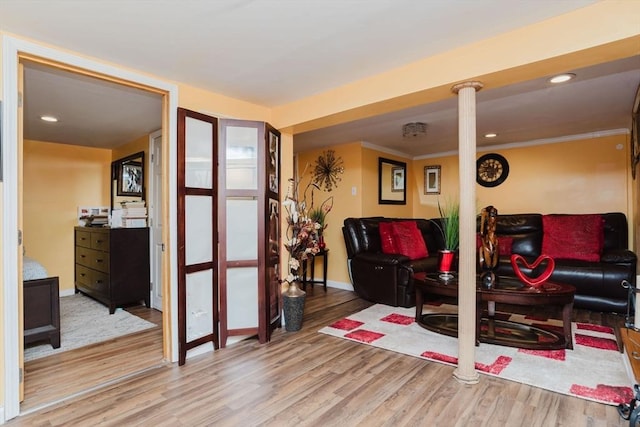 living room with hardwood / wood-style flooring and ornamental molding