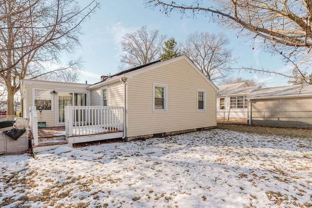 snow covered rear of property featuring a wooden deck