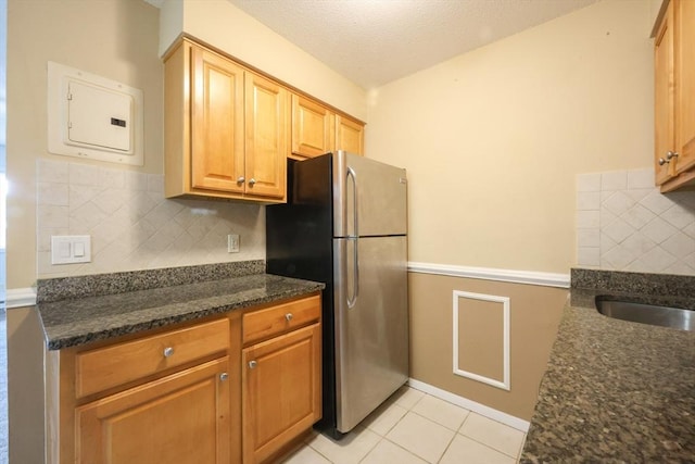 3 Dailey St Unit I, Attleboro, MA 02703 - kitchen with freestanding refrigerator, electric panel, decorative backsplash, dark stone countertops, and light tile patterned floors