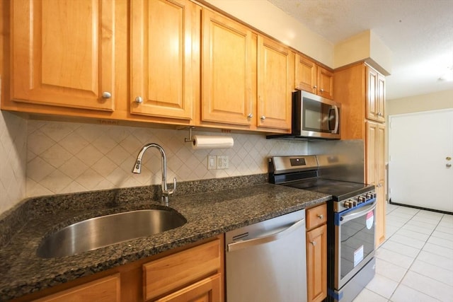 3 Dailey St Unit I, Attleboro, MA 02703 - kitchen featuring appliances with stainless steel finishes, a sink, light tile patterned floors, tasteful backsplash, and dark stone countertops