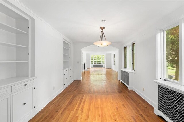 220 Prospect St, Seekonk, MA 02771 - corridor featuring light wood-style floors, radiator heating unit, arched walkways, built in features, and baseboards