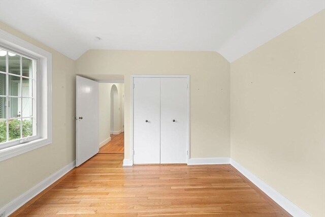 220 Prospect St, Seekonk, MA 02771 - unfurnished bedroom with vaulted ceiling, arched walkways, light wood-style flooring, baseboards, and a closet