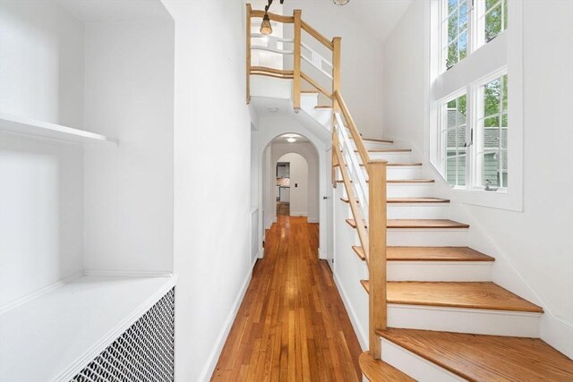 220 Prospect St, Seekonk, MA 02771 - stairs with arched walkways, a towering ceiling, wood finished floors, and baseboards
