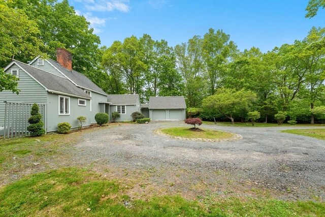 220 Prospect St, Seekonk, MA 02771 - view of front of house with a chimney, driveway, roof with shingles, an attached garage, and view of scattered trees