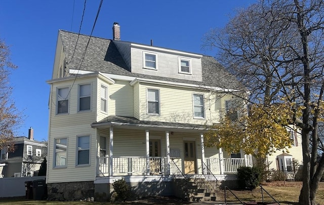 view of front of house with a porch, roof with shingles, and a chimney