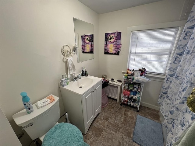 bathroom featuring vanity, baseboards, stone finish flooring, curtained shower, and toilet