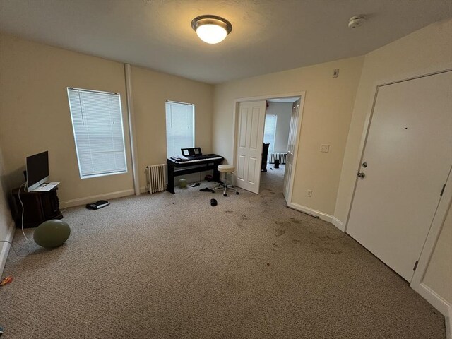 interior space with baseboards, carpet floors, and radiator