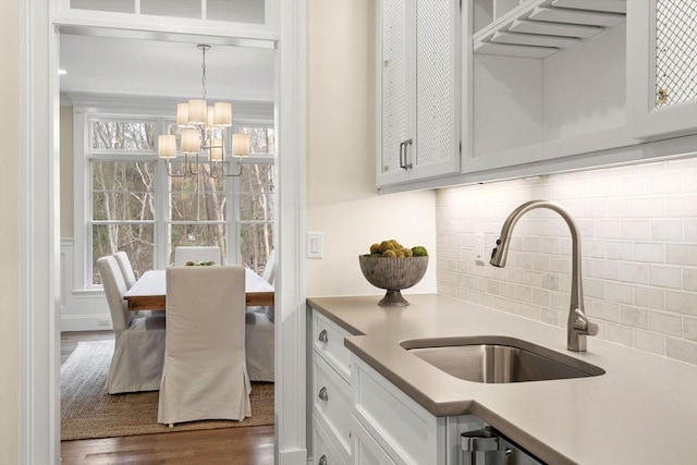 kitchen featuring white cabinets, plenty of natural light, pendant lighting, and sink