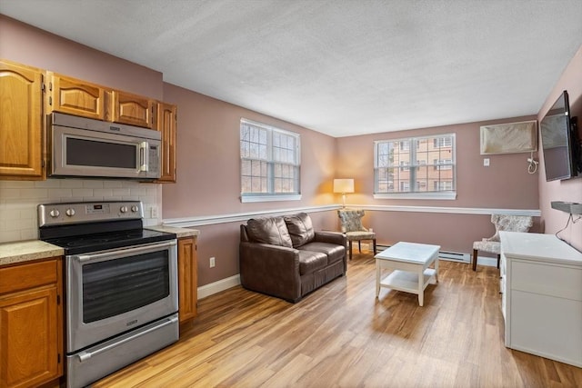 kitchen with light countertops, a wealth of natural light, light wood-style floors, and appliances with stainless steel finishes