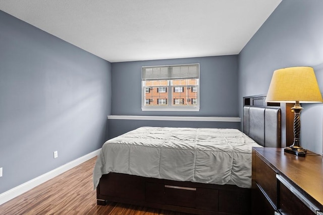 bedroom with baseboards and wood finished floors