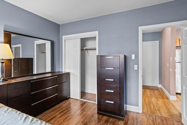 unfurnished bedroom with a closet, baseboards, and wood finished floors