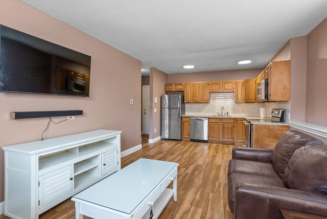 living area featuring recessed lighting, light wood-type flooring, and baseboards