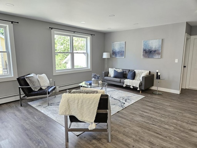 living room with wood-type flooring and a baseboard heating unit