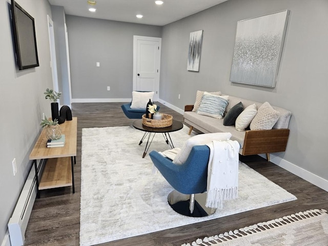 living room with a baseboard heating unit and dark hardwood / wood-style floors