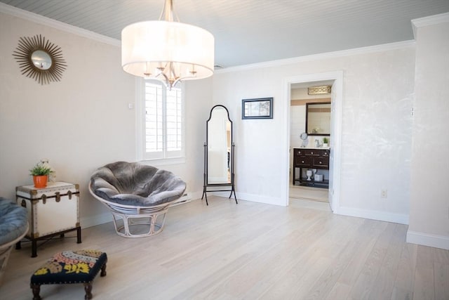 living area with a chandelier, baseboards, wood finished floors, and crown molding