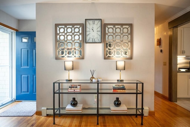 entryway with a baseboard radiator, baseboards, and wood finished floors