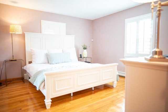 bedroom featuring light wood-type flooring and a baseboard radiator