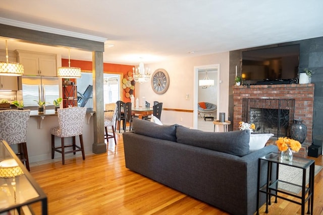 living room featuring a fireplace, light wood-style floors, and baseboards