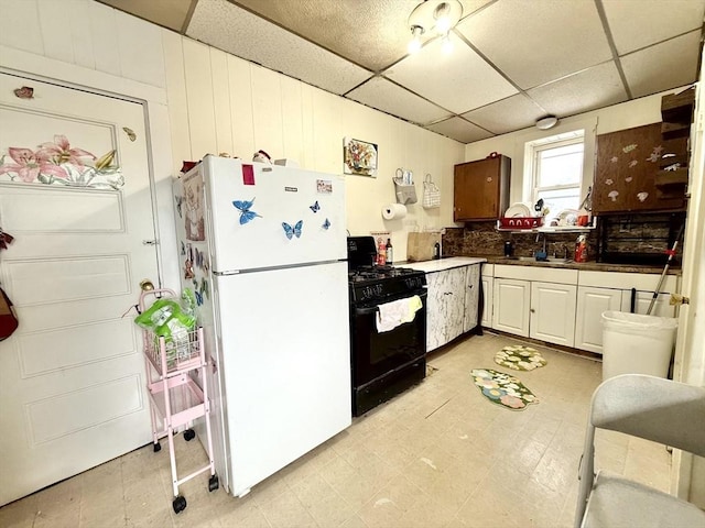 262 Adams St, Newton, MA 02458 - kitchen featuring gas stove, freestanding refrigerator, a paneled ceiling, dark countertops, and light flooring