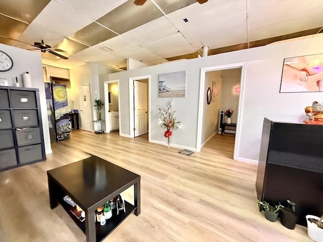 262 Adams St, Newton, MA 02458 - living area with light wood-type flooring, ceiling fan, baseboards, and a paneled ceiling