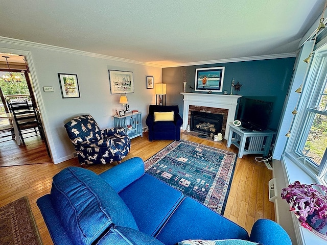 living room featuring a wealth of natural light, a brick fireplace, and hardwood / wood-style floors