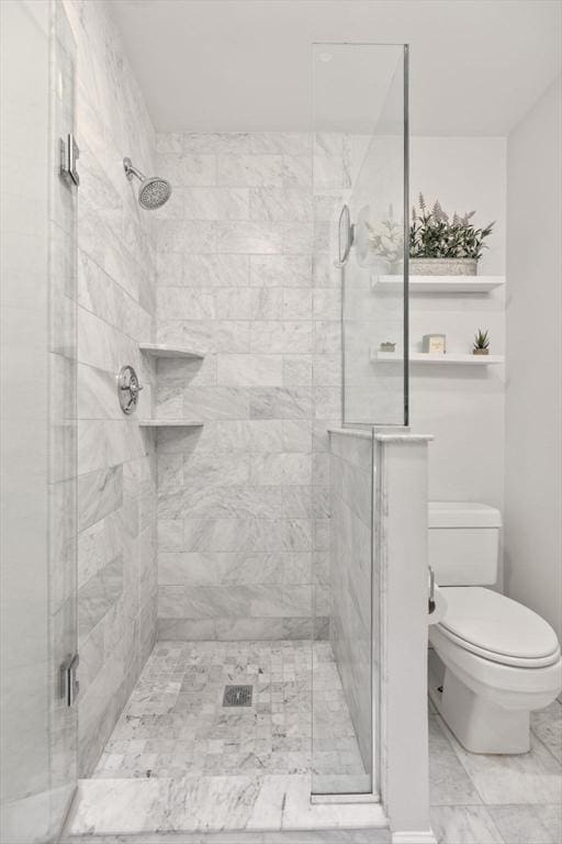 bathroom featuring a stall shower and toilet