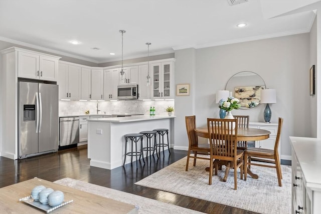 kitchen featuring glass insert cabinets, appliances with stainless steel finishes, white cabinets, and a peninsula